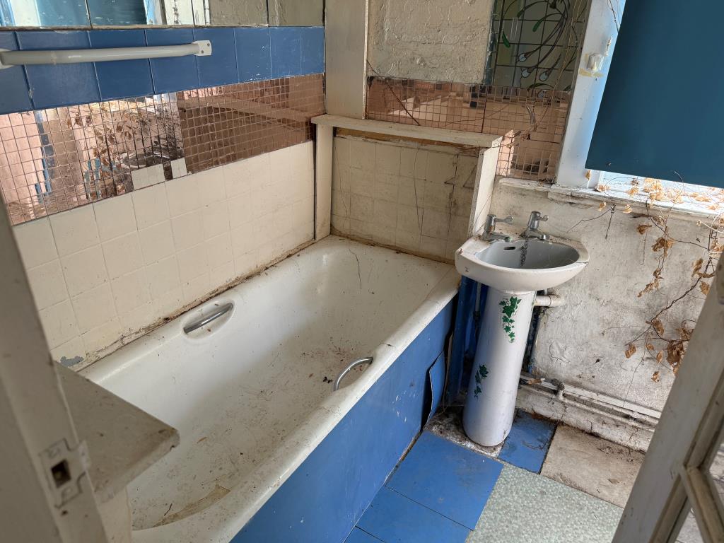Lot: 146 - PATIO FLAT IN NEED OF REFURBISHMENT - Bathroom with white bath and sink units